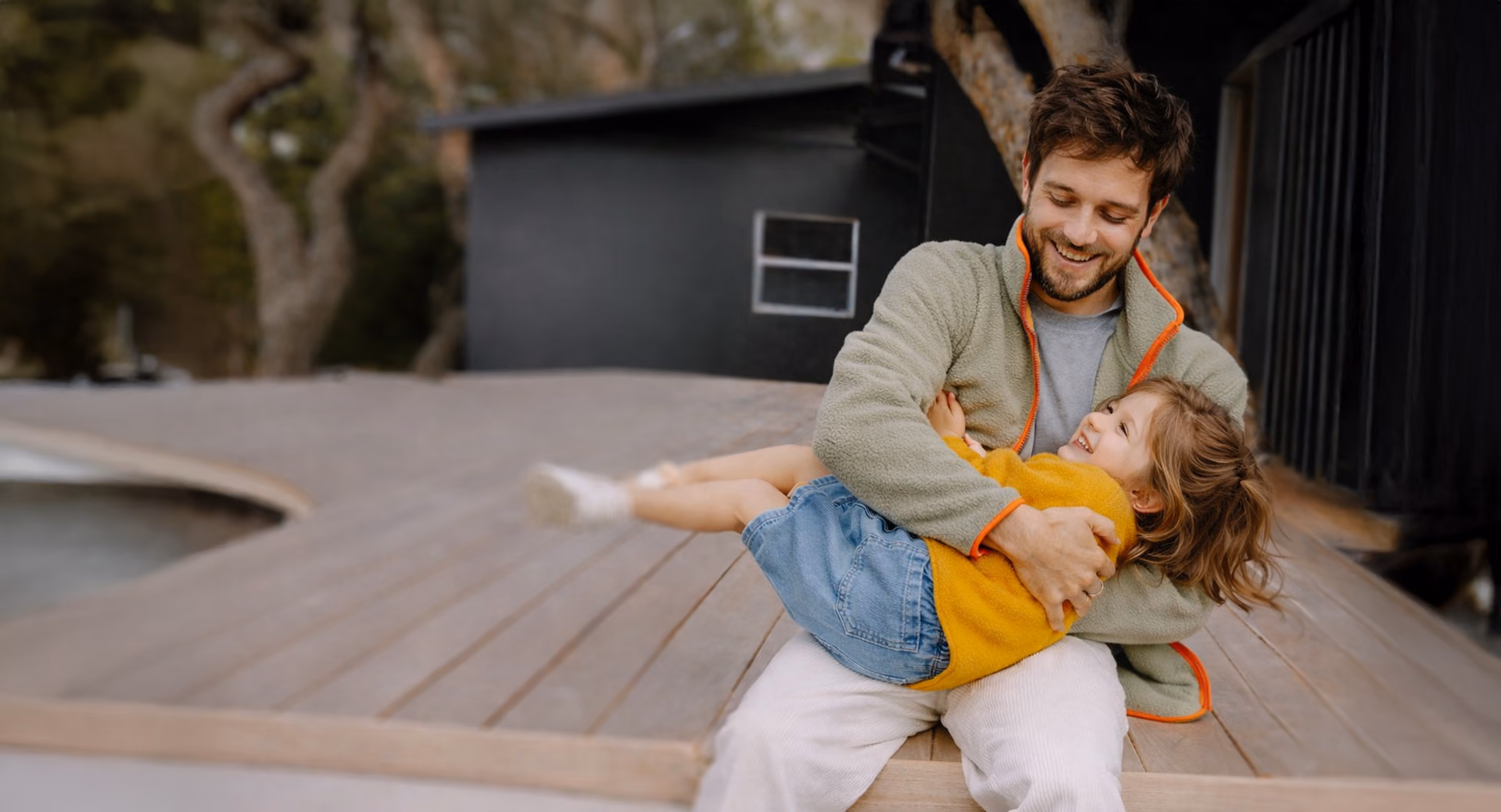 Father holding his daughter outside on a terrace