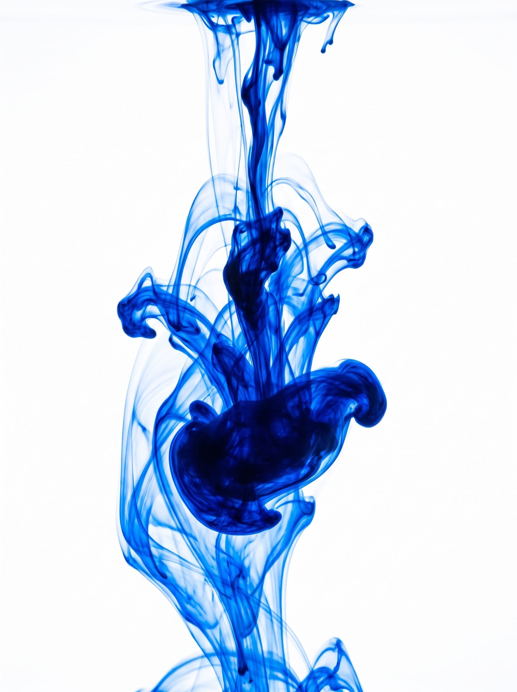 A drop of blue dispersing through clear water